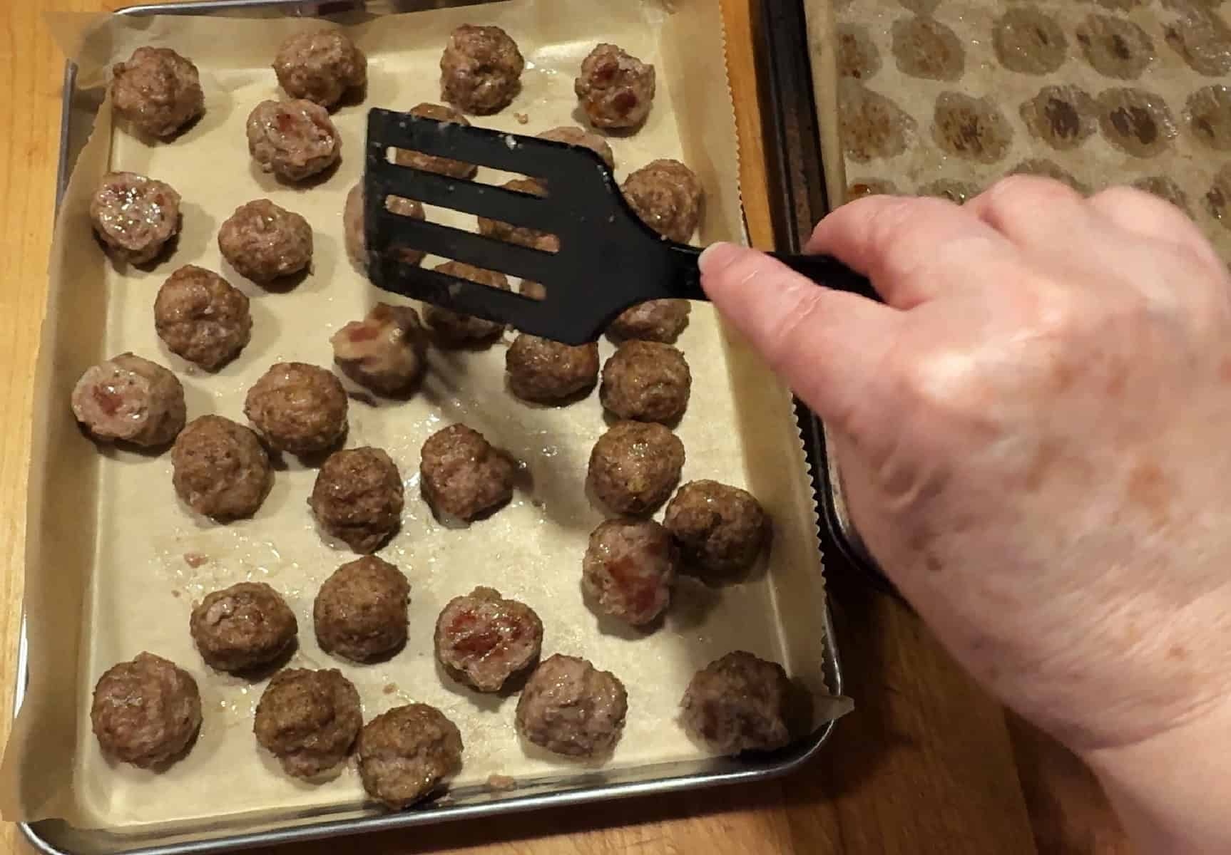 transferring meatballs to a clean tray.