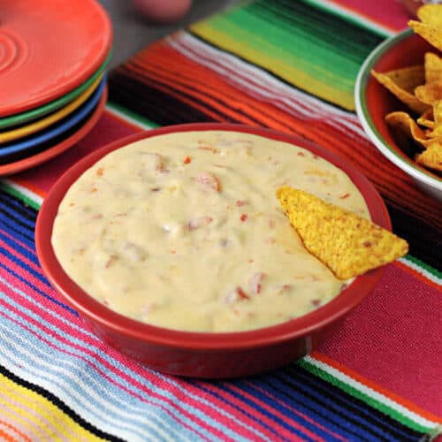 queso dip in a red bowl.
