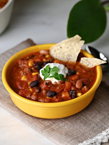 Single bowl of taco chili with sour cream, ready to eat.