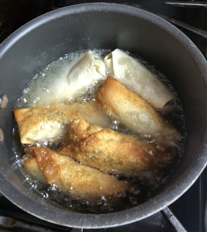 egg rolls cooking in oil