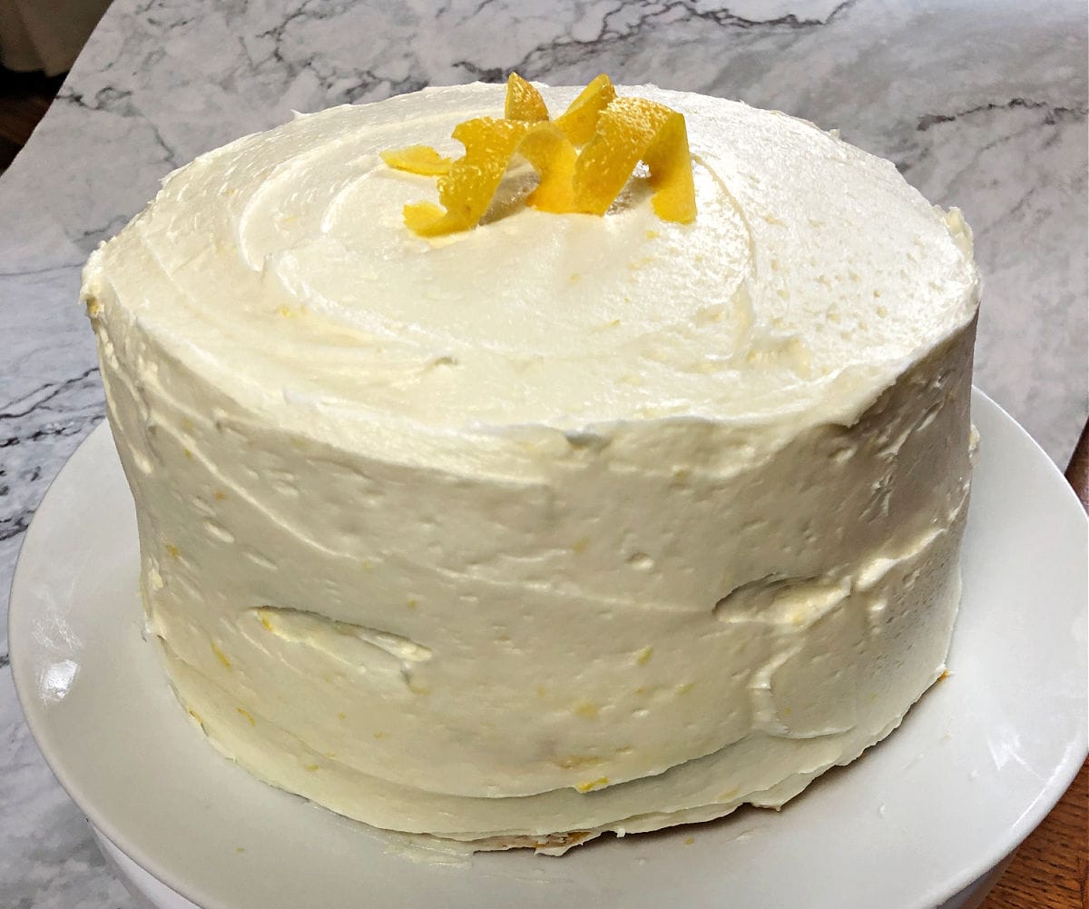 Fully assembled and frosted lemon layer cake.