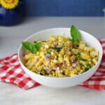 a white serving bowl of fresh corn salad.