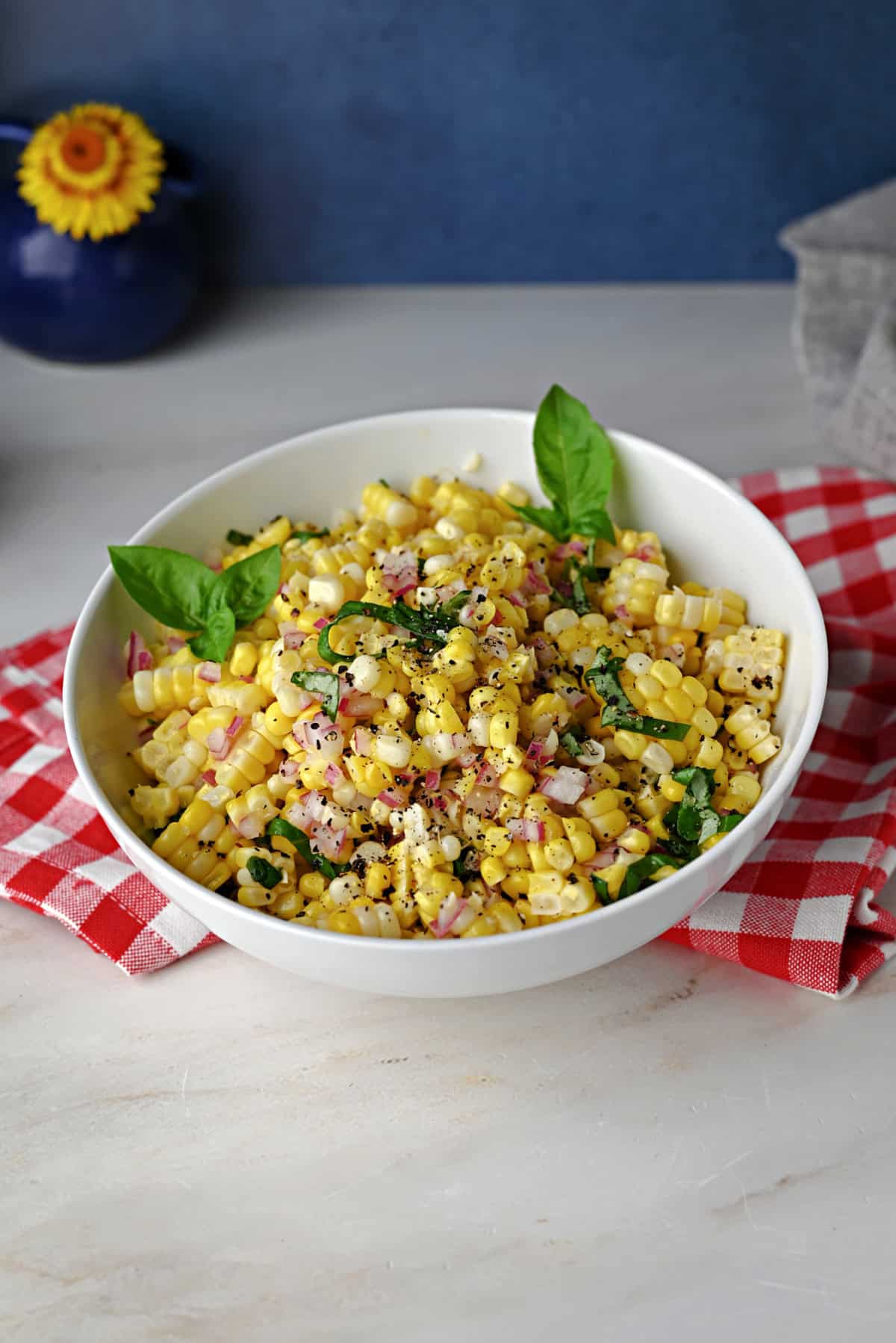Corn salad in a white bowl, ready to serve.