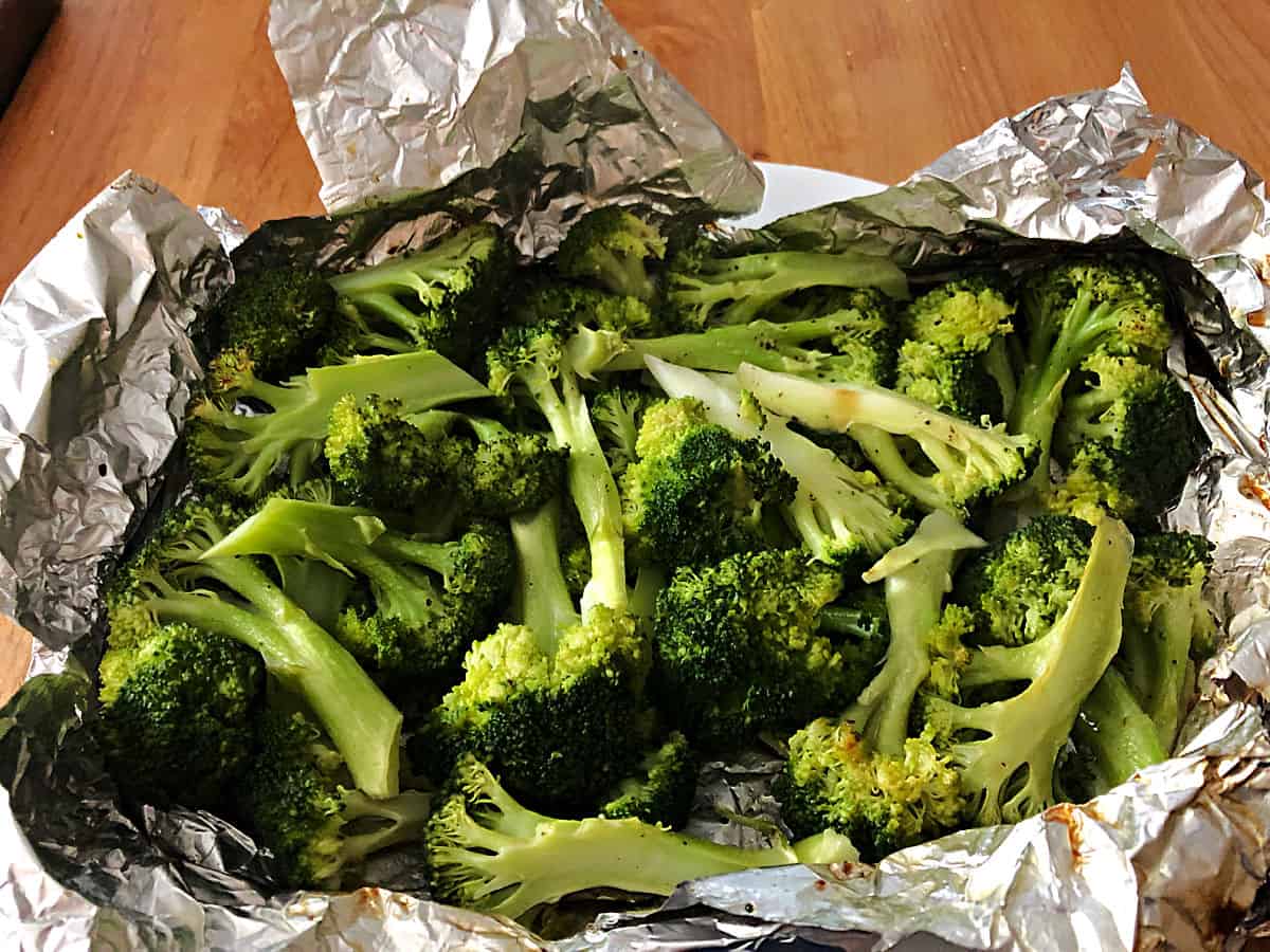 Close up of foil packet opened to see grilled broccoli.