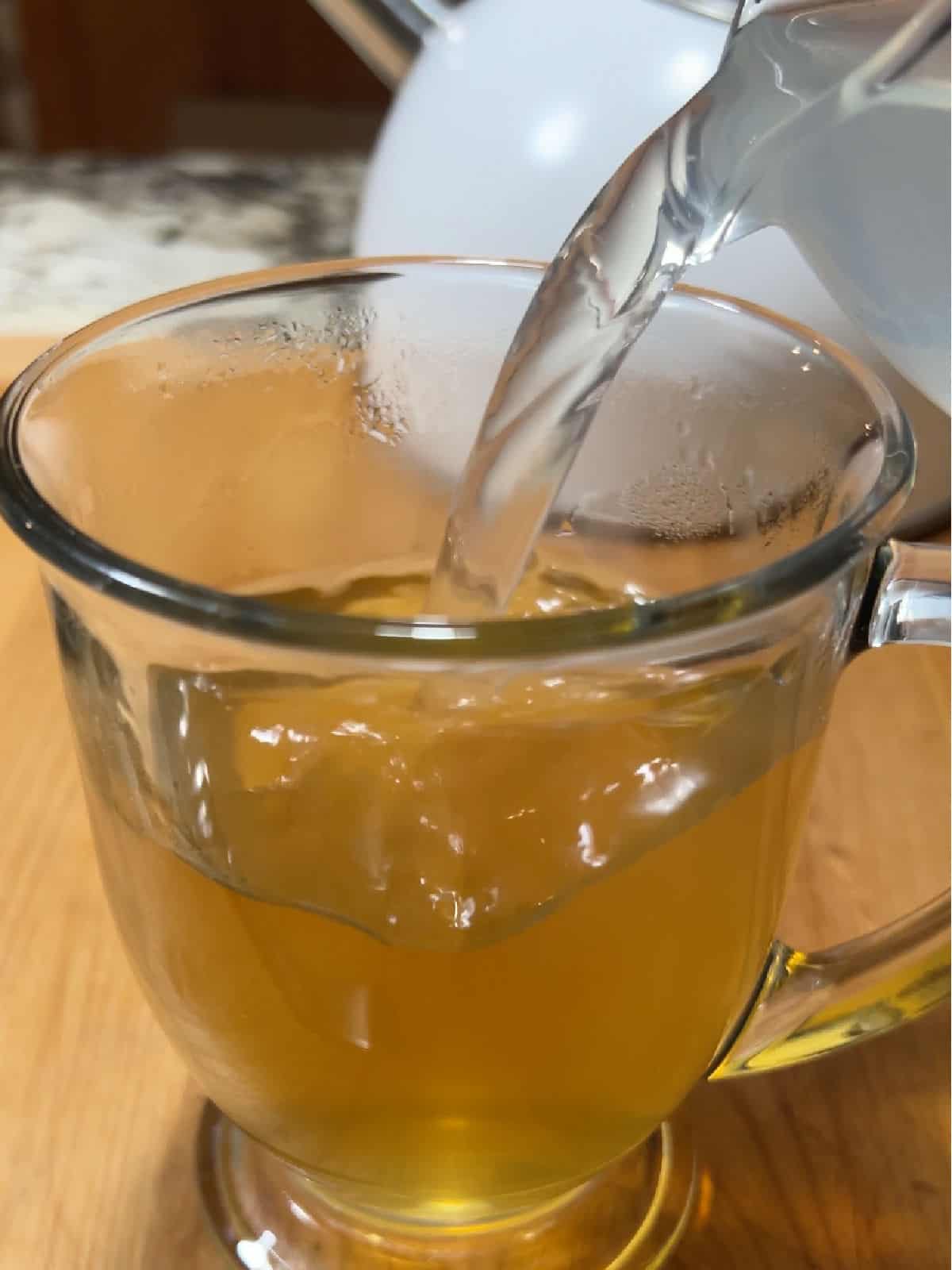 Pouring hot lemonade into the mug of tea.