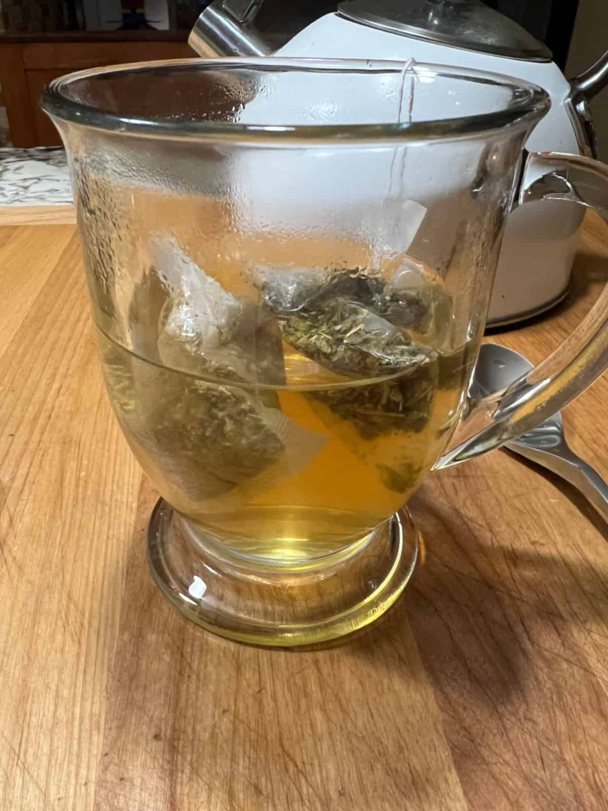 Green and peach tea steeping in the cup.