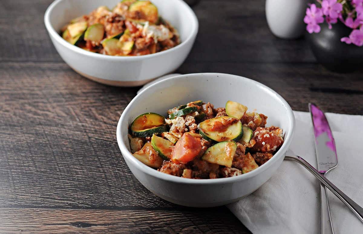 2 small bowls of zucchini and ground beef casserole ready to eat.