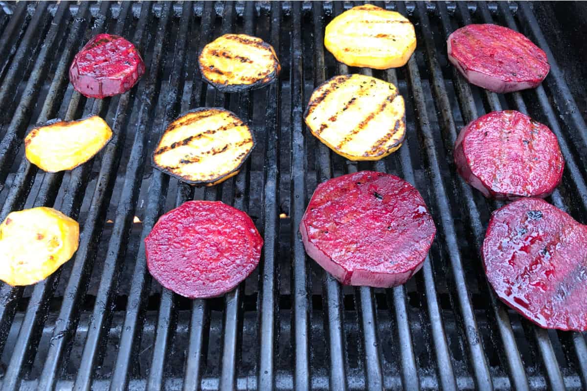 slices of red and golden beet cooking on a grill