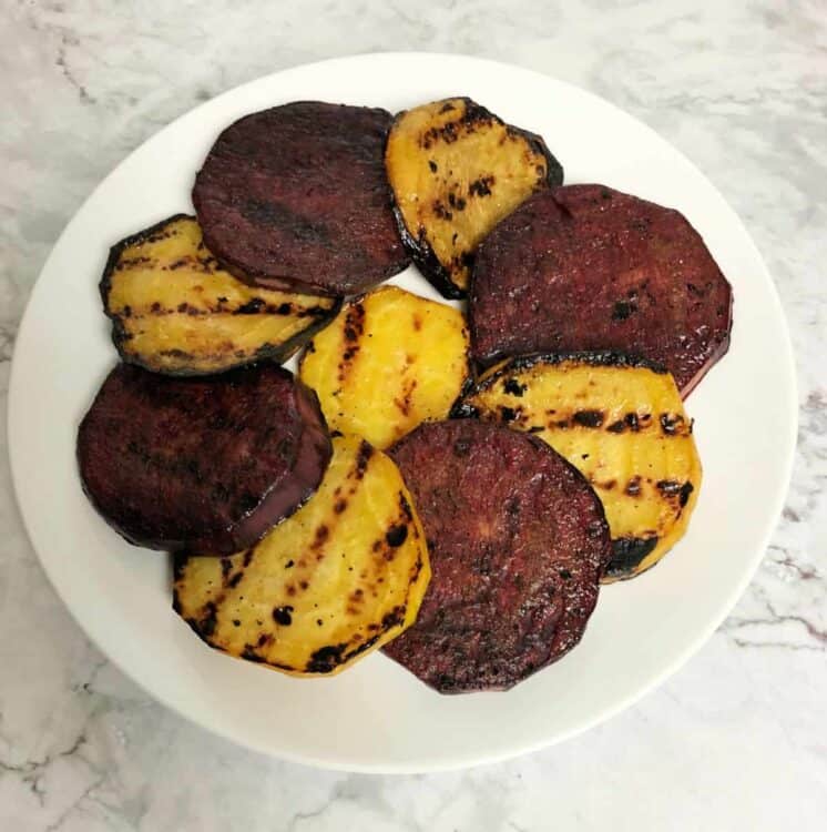 grilled red and golden beets on a white plate