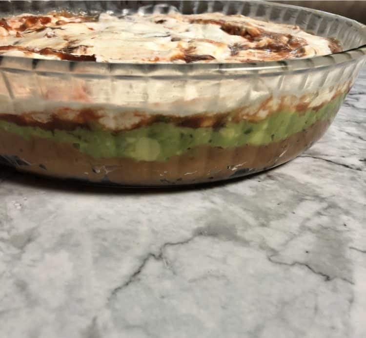 layered taco dip in a glass pan