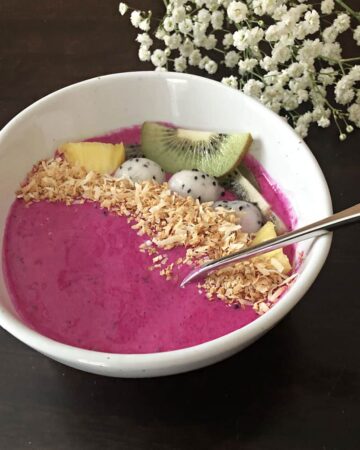 dragon fruit smoothie bowl garnished with toasted coconut and kiwi
