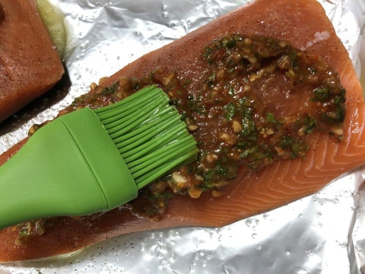 spreading sauce on raw salmon