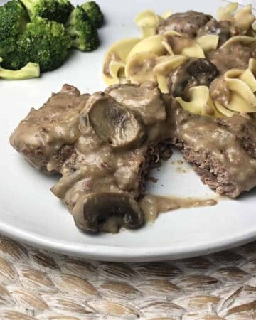 Instant pot cube steak with noodles on a white plate