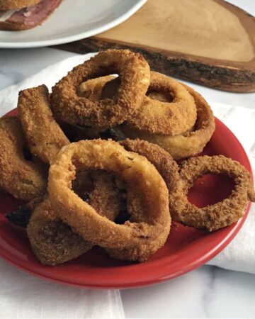 Air Fryer Frozen Onion rings on a small red plate
