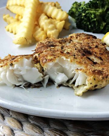 Potato crusted cod on a white plate
