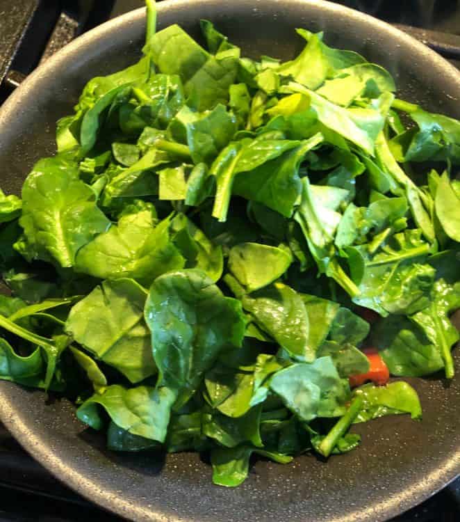 fresh spinach added to skillet