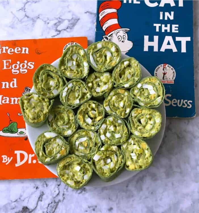 Egg salad pinwheels on a white plate with Dr Seuss books behind