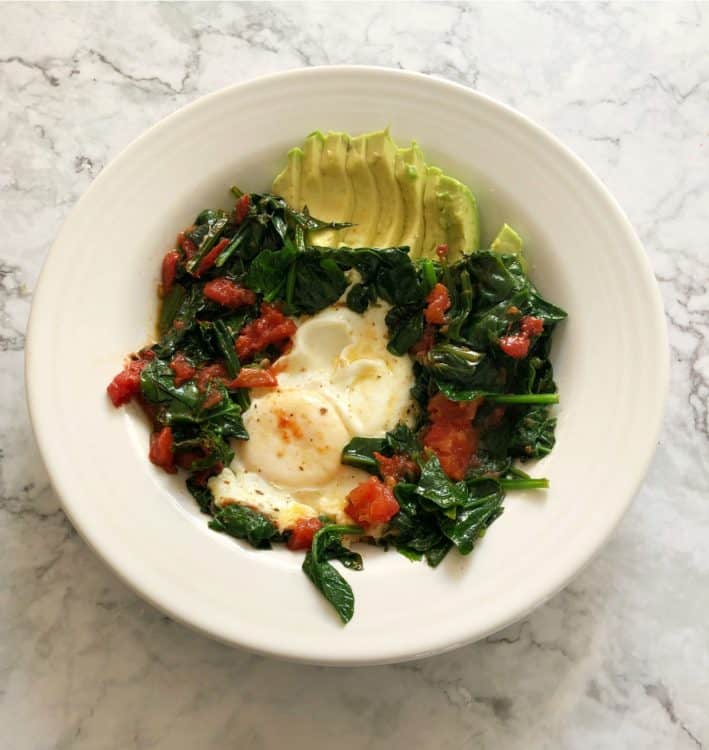eggs and veggies in a white bowl with avocado