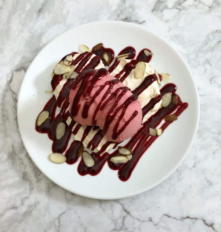 meringue heart with lots of raspberry sauce on it
