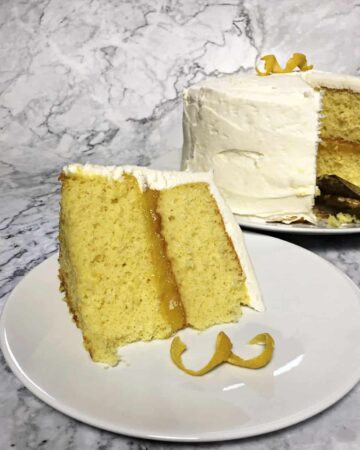 Lemon layer cake sliced with whole cake behind