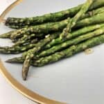 pan fried asparagus on a gold rimmed plate