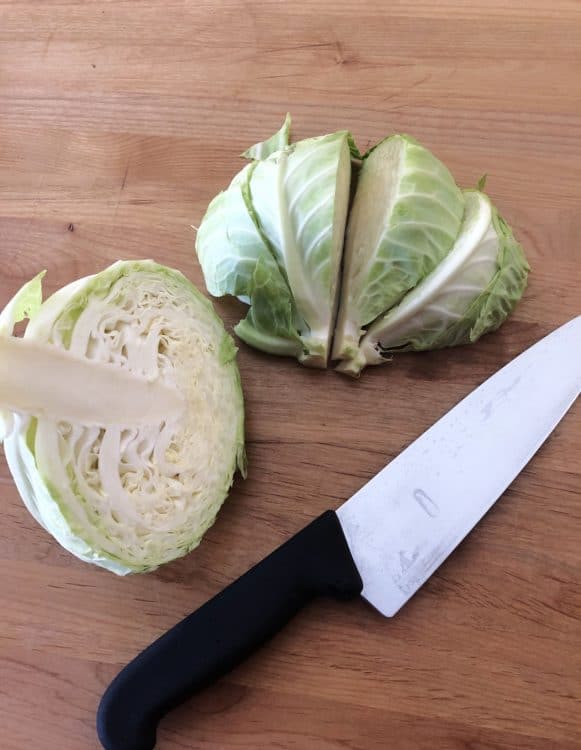 knife with cabbage wedges on a cutting board