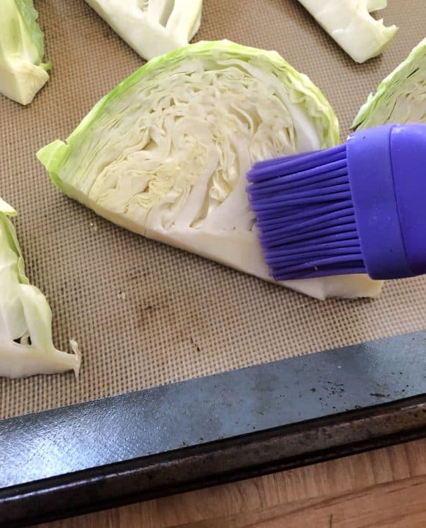pastry brush adding oil to cabbage wedges
