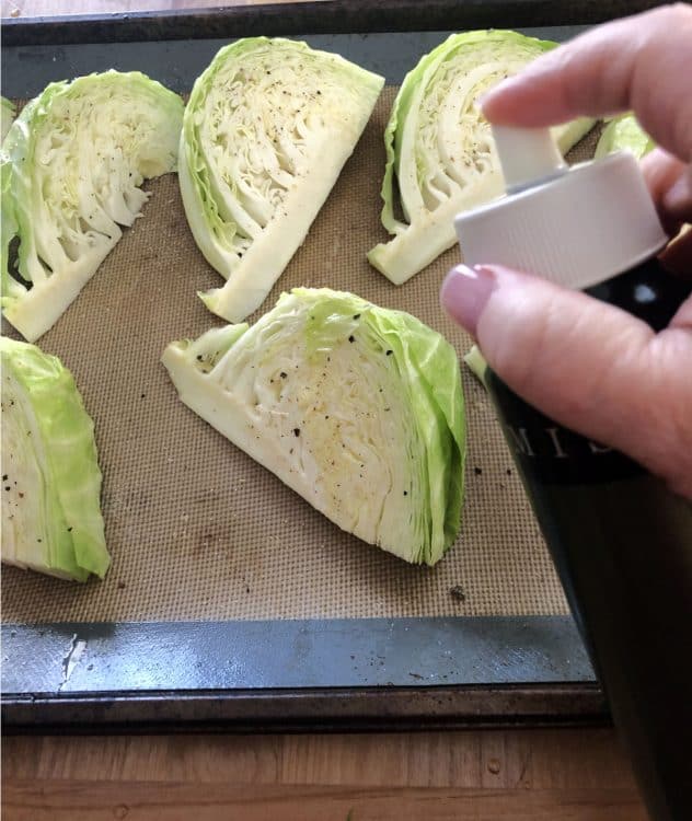 mister spraying oil on the wedges of cabbage