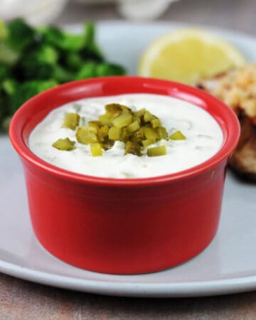small bowl of homemade keto tartar sauce garnished with chopped pickle.