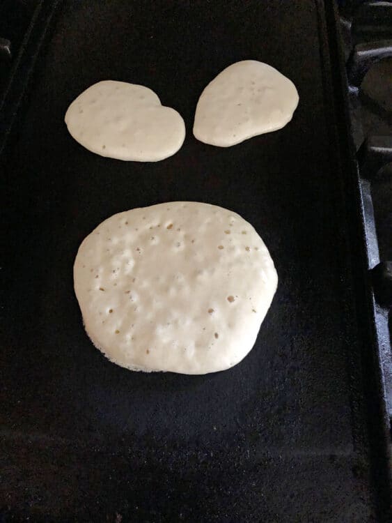 pancake batter cooking on a griddle