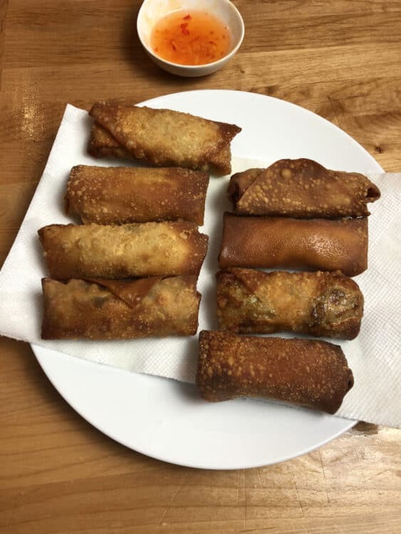 homemade egg rolls draining on paper towel lined plate