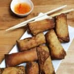 arrangement of homemade eggg rolls on a platter with dipping sauce