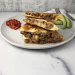 ground beef quesadilla quarters stacked on a plate