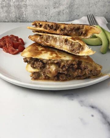 ground beef quesadilla quarters stacked on a plate