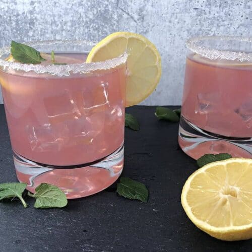 Pink senorita 2 drinks garnished with lemon slices and mint