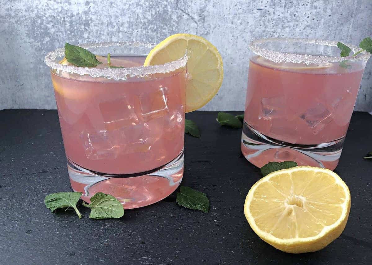 Pink senorita 2 drinks garnished with lemon slices and mint