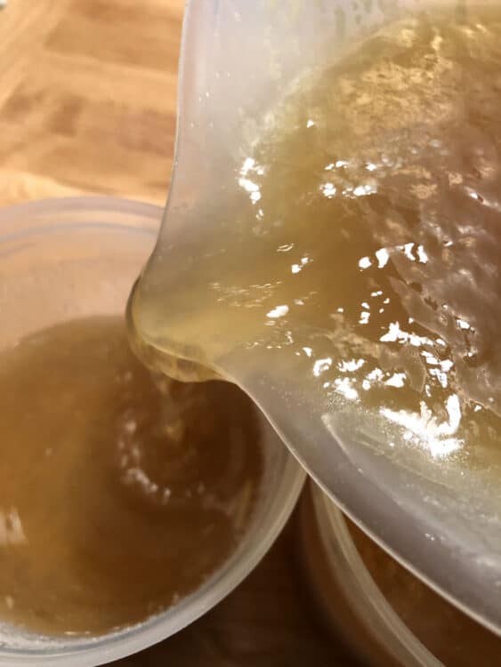 bone broth being poured into a jar