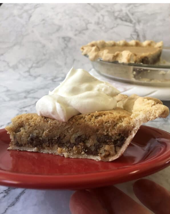 slice of Derby Pie with whipped cream on a red plate