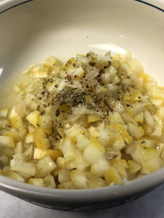 close up of whole lemon dressing in a bowl