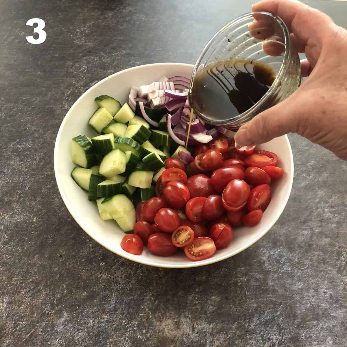 beginning to pour dressing on the veggies