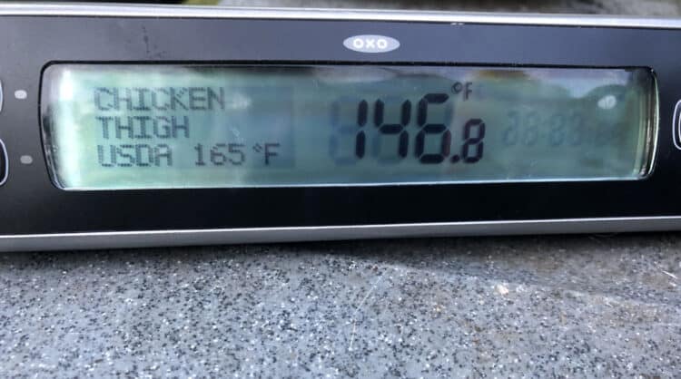 meat thermometer showing progress toward optimal temperature for chicken legs on the grill