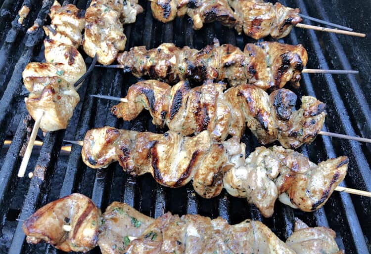 chinese chicken skewers (chicken on a stick) cooking on a BBQ grill