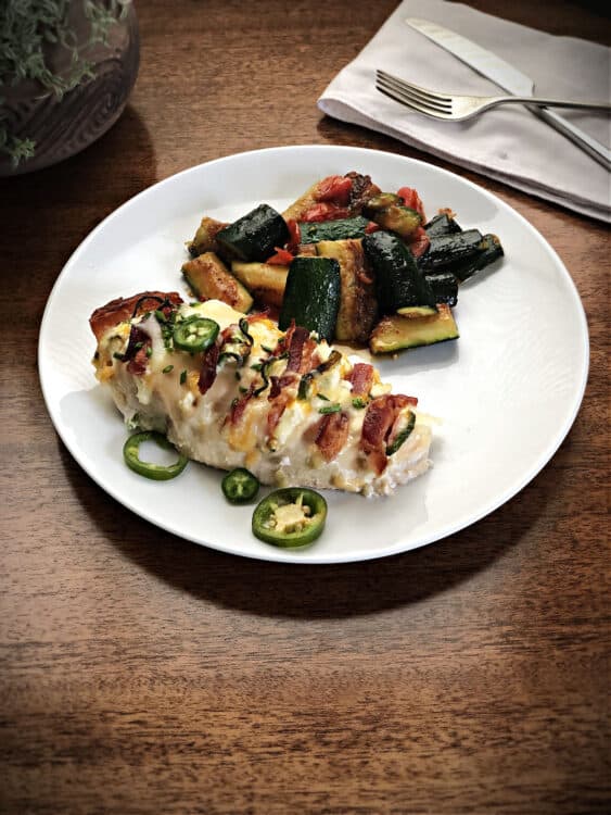 Jalapeno Popper Hasselback Chicken on a plate with zucchini