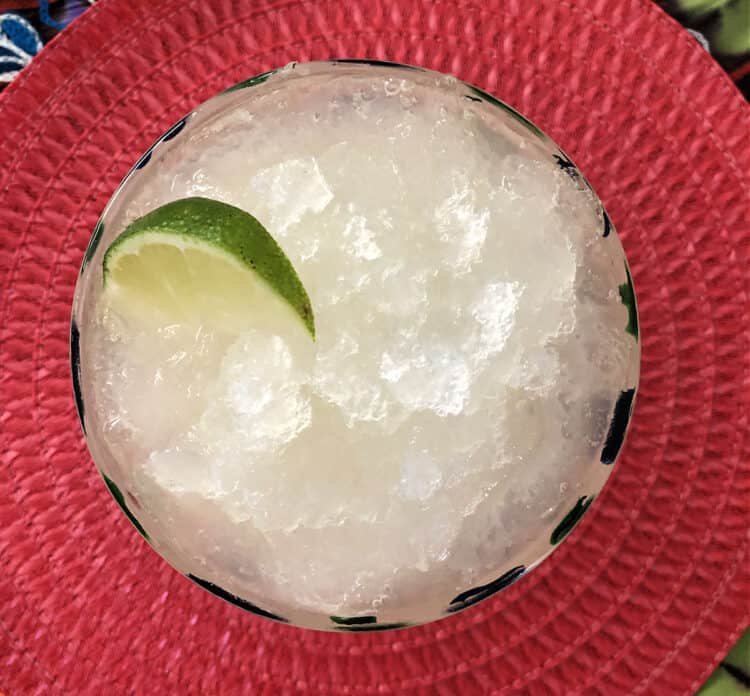 top down view of margarita slush in a glass with a wedge of lime