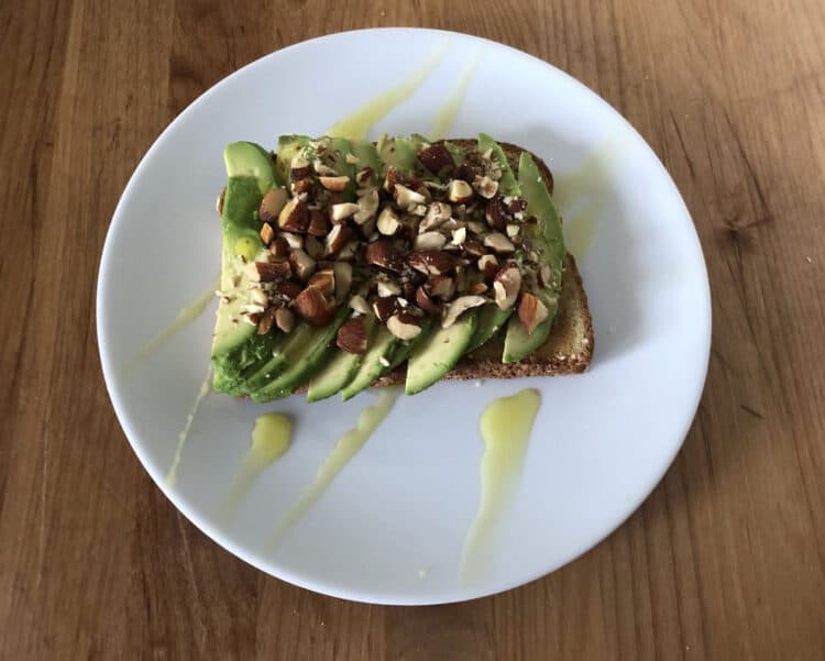 toast with avocado and chopped nuts, a drizzle of olive oil