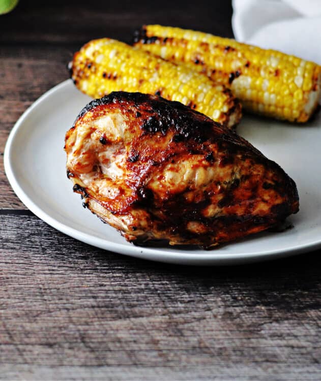 top down view of keto bbq chicken on a plate with 2 ears of sweet corn