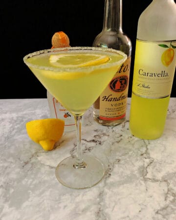 limoncello martini with liqueur bottles behind