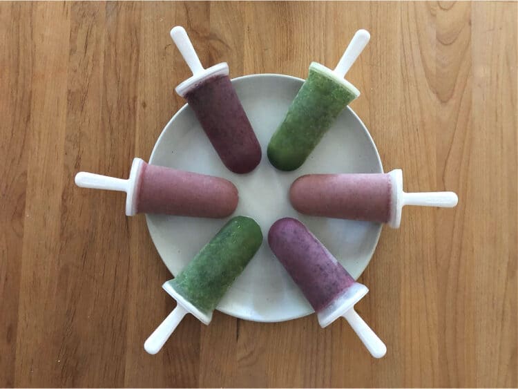 6 popsiclesarranged in a circle or wheel shape on a white plate