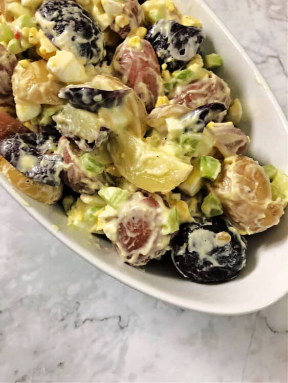 red white and blue potato salad in a serving bowl