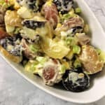 res white and blue potato salad in a serving bowl
